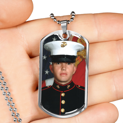Silberfarbener Dog-Tag-Fotoanhänger in der Hand als Größenvergleich