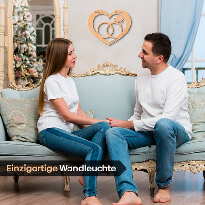 Herzförmiges Holzschild mit verschlungenen Ringen für Hochzeitsnamen und Datum